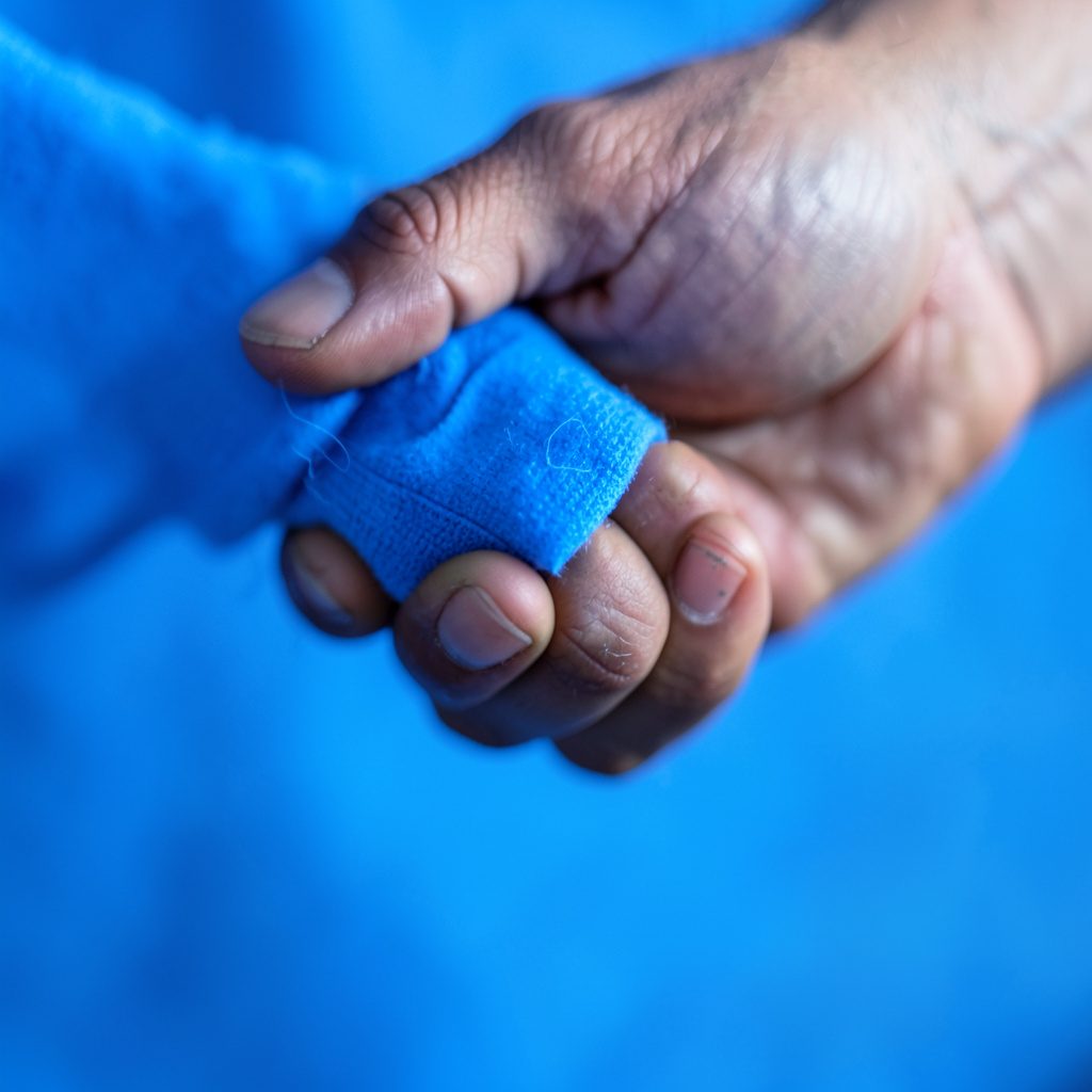 A close-up photograph of two hands meeting in a professional handshake, warm neutral skin tones against a soft blurred office background.